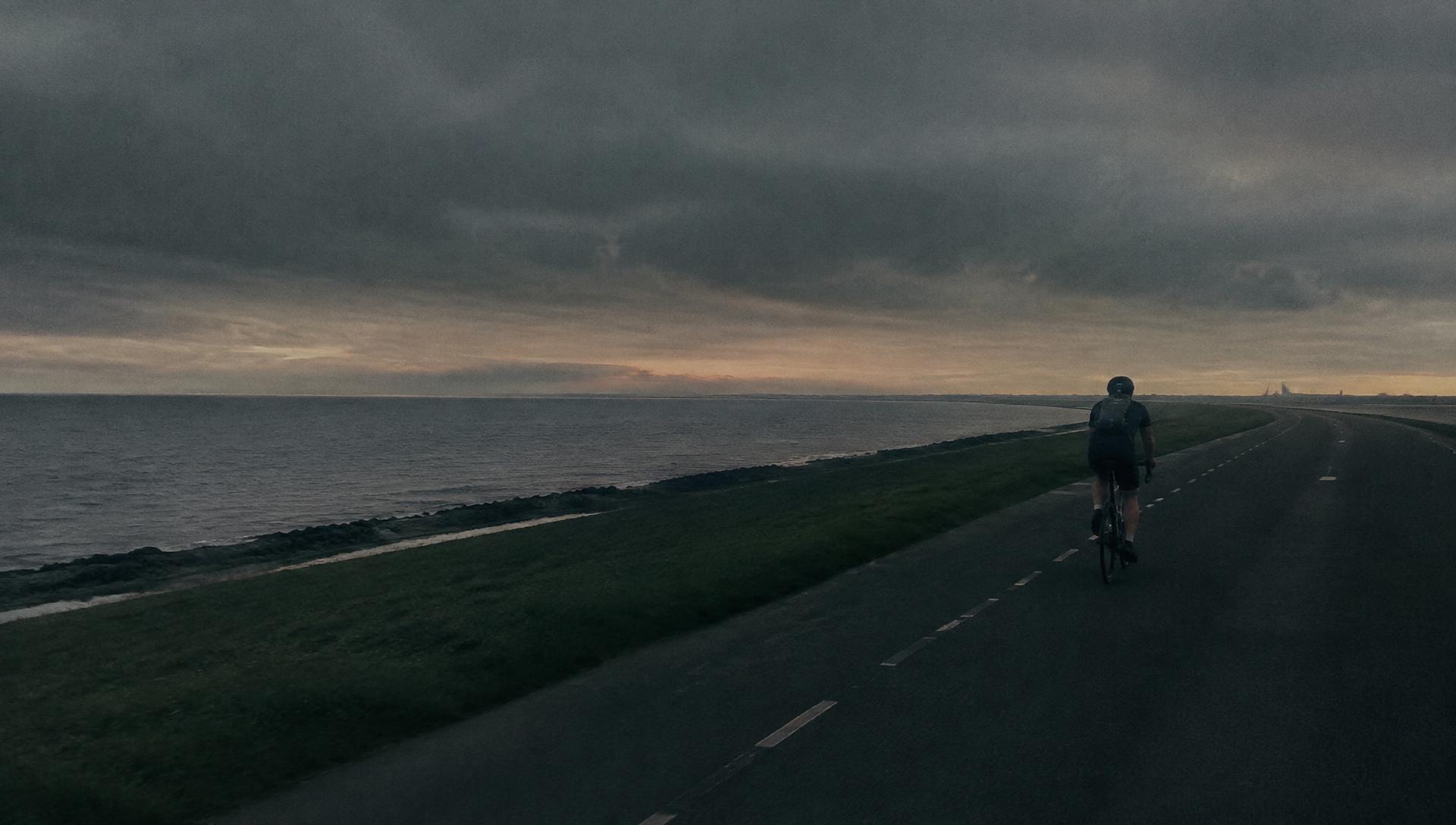 Cycliste solitaire sur la digue d'Ostende à l'aube